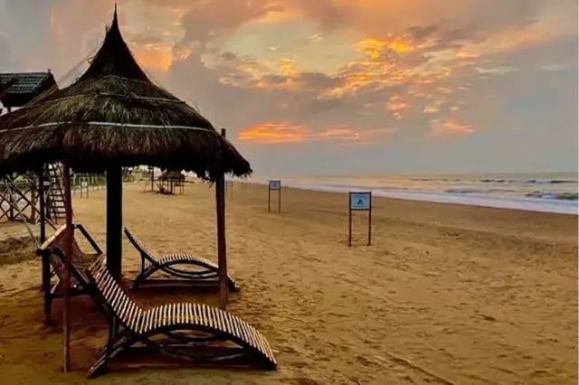 Shaded loungers on Puri beach at golden hour